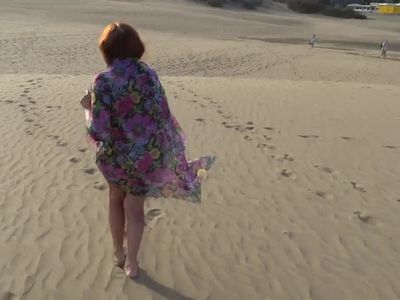 Mature woman posing on the beach and the dunes